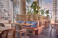 a bench in a restaurant with tables and chairs at DoubleTree by Hilton Rotterdam Centre in Rotterdam