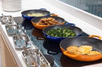 four bowls of food on a counter with bowls of broccoli at Home2 Suite by Hilton Xishuangbanna Jinghong in Jinghong