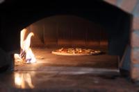 una pizza está cocinando en un horno de ladrillo en Gostilna in picerija Harlekin, en Ribnica