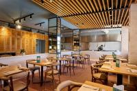 a restaurant with wooden tables and chairs and a counter at Grupotel Cala Marsal Nature Hotel in Portocolom