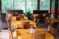 Madandanにあるwisma rotterdamの黄色のテーブルと椅子、窓のあるレストラン