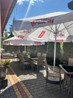 Zajazd pod Jarem في بالتو: فناء به طاولات وكراسي ومظلات