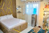 Un dormitorio con una cama y un televisor. en Le Cristal de Roche, en Pointe-Noire