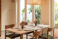 Una mesa de comedor con sillas y una gran ventana. en Palácio de Tavira, a Small Luxury Hotel of the World, en Tavira