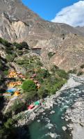 un grupo de casas en una colina junto a un río en Llahuar Lodge, en Cabanaconde