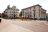 an empty street with buildings and tables and umbrellas at Hotels &amp; Résidences - Les Thermes in Luxeuil-les-Bains