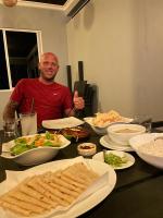 un hombre sentado en una mesa con platos de comida en Rihiveli inn, 