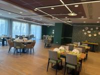 ein Restaurant mit Tischen und Stühlen in einem Raum in der Unterkunft DOMITYS - La Florentine in Sarreguemines