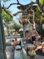 a group of people sitting on benches at a resort at The Beachbreaks Medewi in Airsatang