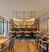 a restaurant with tables and chairs and a chandelier at MACAM Hotel in Lisbon