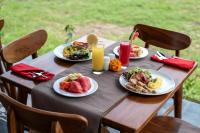 Embun Pagi Wooden Private Villas Ubud في تيغالالانغْ: طاولة عليها أطباق من المواد الغذائية والمشروبات