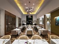 a restaurant with white tables and chairs and a chandelier at St. Regis Macao in Macau