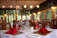 アルーシャにあるArusha Farm Houseの赤いナプキンとグラスが置かれたレストランのテーブル