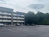 Un estacionamiento con autos estacionados frente a un edificio. en Studio 6 West Columbia, SC - Airport, en West Columbia