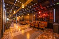 a restaurant with wooden tables and chairs in a room at Accent Park Opp Corporate Hub, 62 in Noida