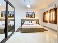 un dormitorio con una cama y un espejo en Touraco Suite Hôtel Business, en Mbour