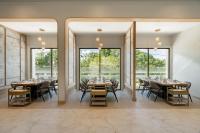 ein Esszimmer mit Tischen und Stühlen und großen Fenstern in der Unterkunft AZ Sunrise Resort & Fitness Club in Layan Beach