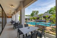 eine Außenterrasse mit Tischen und Stühlen neben einem Pool in der Unterkunft AZ Sunrise Resort & Fitness Club in Layan Beach