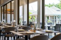 eine Reihe von Tischen in einem Zimmer mit Fenstern in der Unterkunft AZ Sunrise Resort & Fitness Club in Layan Beach