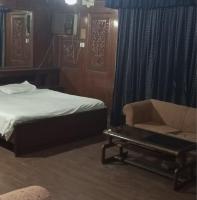 Un dormitorio con una cama, un sofá y una silla. en SSClub Hotel Peshawar, en Peshawar