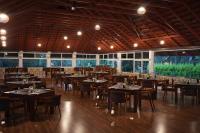 uma grande sala de jantar com mesas e cadeiras em Coorg Orange Blossom Resort and Spa em Suntikoppa