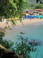 uma vista de uma praia com cadeiras e areia em Pousada Traineira em Paraty