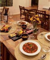 a wooden table with plates of food and wine glasses at Hotel El Candil Tilcara in Tilcara