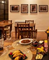a table with a plate of food and wine glasses at Hotel El Candil Tilcara in Tilcara