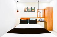 Un dormitorio con una cama blanca con almohadas negras. en Super Townhouse Rajahmundry, en Rajahmundry
