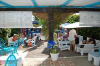 a group of people sitting on tables and chairs under an umbrella at Bungalows Tangana in Tarifa