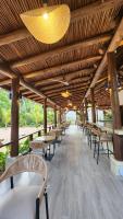 Una fila de mesas y sillas bajo un techo de madera. en Pineapple Beach Villas, en Baie Lazare Mahé