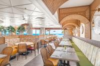a restaurant with tables and chairs in a room at Henann Premier Coast Resort in Panglao