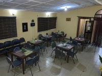 a dining room with tables and chairs in a room at Optizee Hotel & Suites in Omole