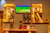 IKORO RESORT Musanze في روهينجيري: تلفزيون معلق على الحائط مع طاولة مع وسائل الترفيه