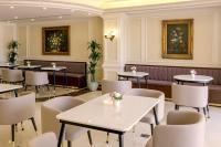 Un restaurante con mesas y sillas en una sala. en Sunset Jeddah, en Yeda