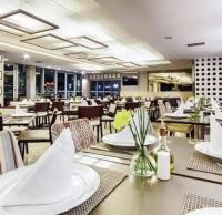 Un comedor con mesas y sillas y un restaurante. en Suíte em Hotel de Luxo Bourbon, en Belo Horizonte