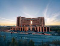 Un edificio de hotel con muchos coches delante. en World Heart Hotel, en Baghdād