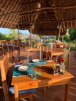 a wooden table in a restaurant with tables and chairs at Pangani Cliffs Lodge in Pangani