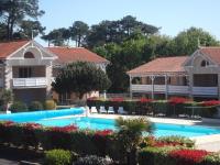 a swimming pool in front of two houses at Résidence Goélia Le Cordouan in Soulac-sur-Mer