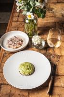 a table with two plates of food and a glass of wine at Domaine des Etangs, Auberge Collection in Massignac