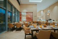 Un restaurante con mesas, sillas y ventanas. en Kandy Myst by Cinnamon, en Kandy