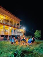 Un grupo de personas sentadas en sillas frente a un edificio. en Neelum Resorts Taobat, en Taobat