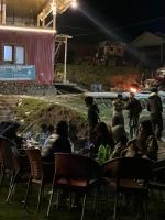 un grupo de personas sentadas en las mesas de noche en Neelum Resorts Taobat, en Taobat