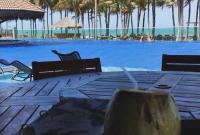 a resort with a pool with chairs and a table at Bangalô Cobertura 4 suítes capacidade 14 pessoas in Aquiraz