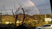 a rainbow in the sky over a city at Slower Life B&amp;B in Jiaoxi