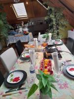 ein Tisch mit einem floralen Tischtuch drauf in der Unterkunft Les jardins d'armance in Le Valdahon