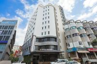 ヴァドーダラーにあるHotel Presidentの前に車が駐車されている白い建物
