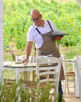 Ein Mann steht an einem Tisch mit einem Tablett voller Cupcakes. in der Unterkunft Borgo Conde Wine Resort in Forlì