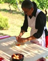 Eine Frau bereitet Essen auf einem Tisch zu, daneben steht eine Schüssel mit Eiern. in der Unterkunft Borgo Conde Wine Resort in Forlì