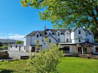una gran casa blanca con un árbol en el primer plano en Broadford Hotel, en Broadford